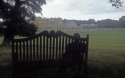 Holkham Hall: Bronzestatue auf einer Bank blickt auf die Südfassade  - Wells-next-the-Sea