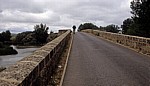 Jakobsweg (Camino Francés): Ein Pilger überquert die Brücke über den Río Pisuerga - Castilla y León